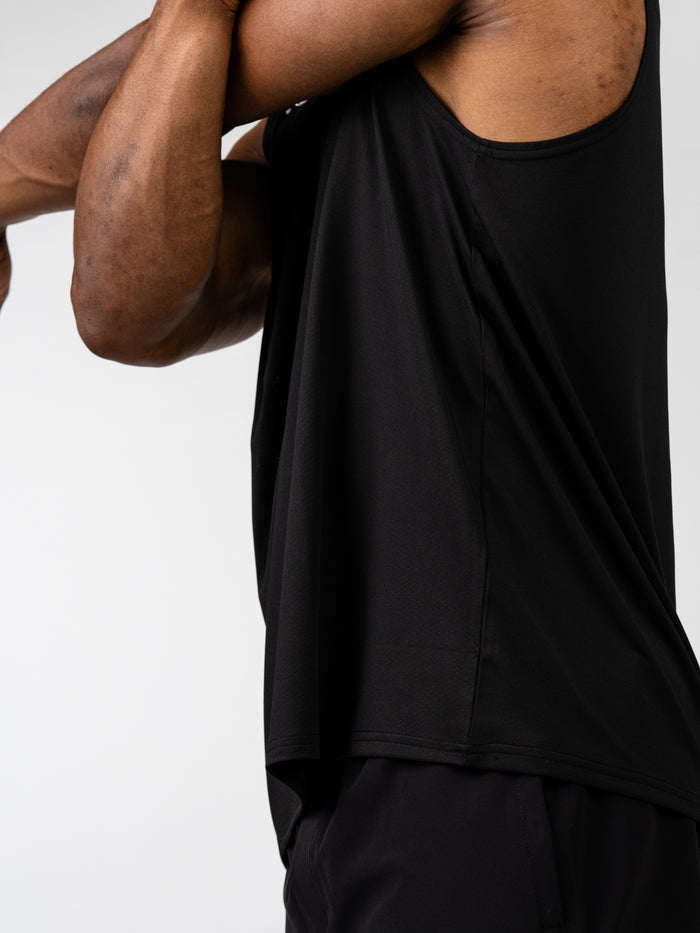 Close-up side view of a person wearing the black Carry Your Cross Premium Oversized Tank, showcasing its loose fit and breathable fabric ideal for Christian fitness apparel and workout wear.