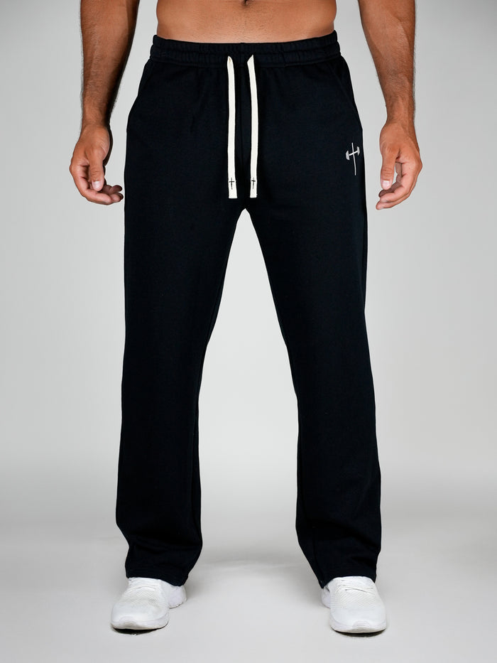 Black sweatpants with a white drawstring on a gray background