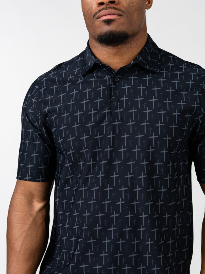 Close-up of a man wearing a black Cross Premium Polo with a subtle pattern of crosses, combining Christian gym clothing style with a clean, performance-focused design.