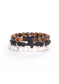 Stack of three beaded bracelets featuring polished tiger eye, matte black, and white marbled beads, each with a cross-shaped centerpiece, representing faith and strength in the Cross Wristband Pack.