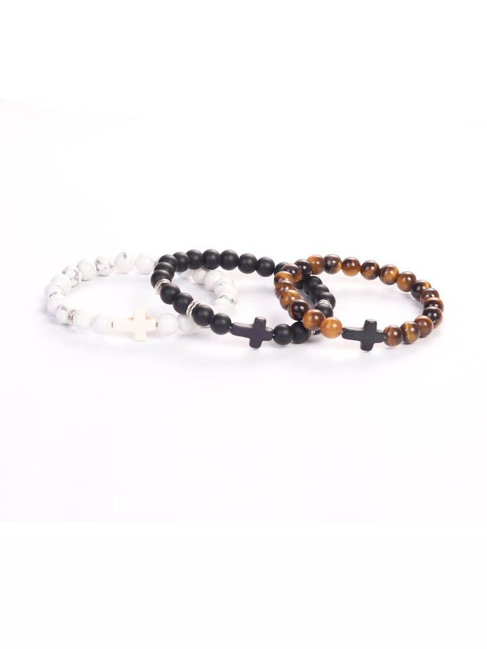 Cross Wristband Pack featuring three beaded bracelets in white, black, and brown tones, each with a cross-shaped bead as a faith-inspired accessory.