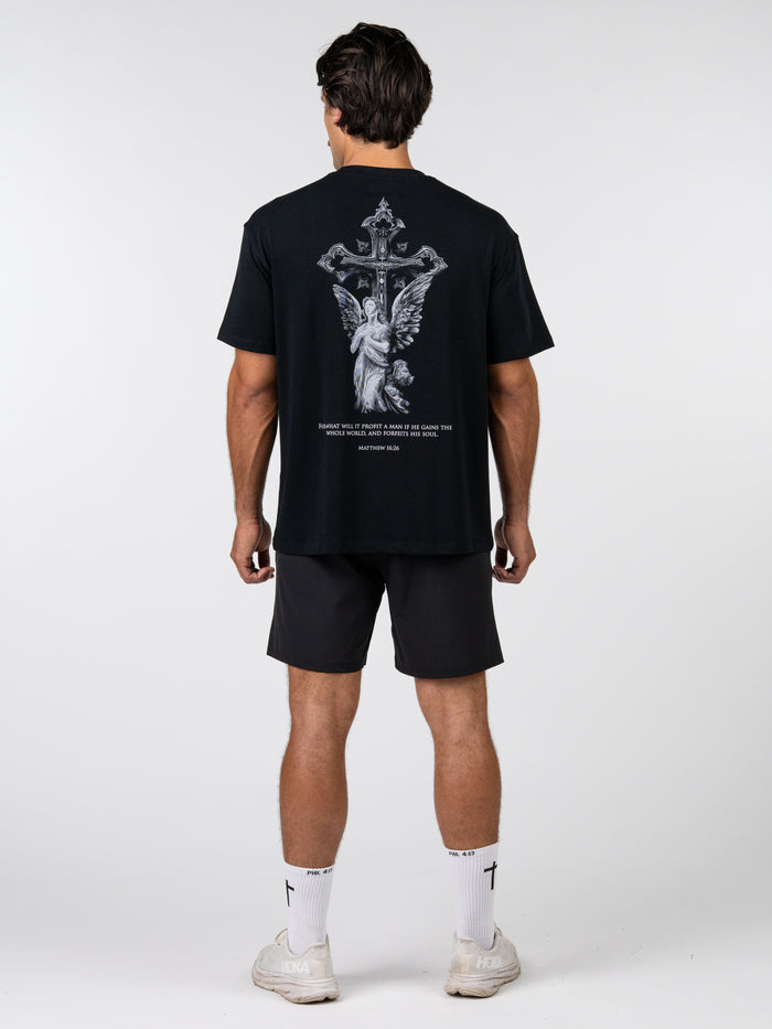 Person wearing a black t-shirt with a graphic design on the back, standing against a white background