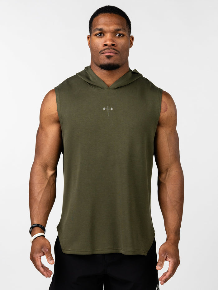 Man wearing an olive green Essential Sleeveless Hoodie featuring a small Christian cross with a barbell design on the chest, paired with black athletic shorts.