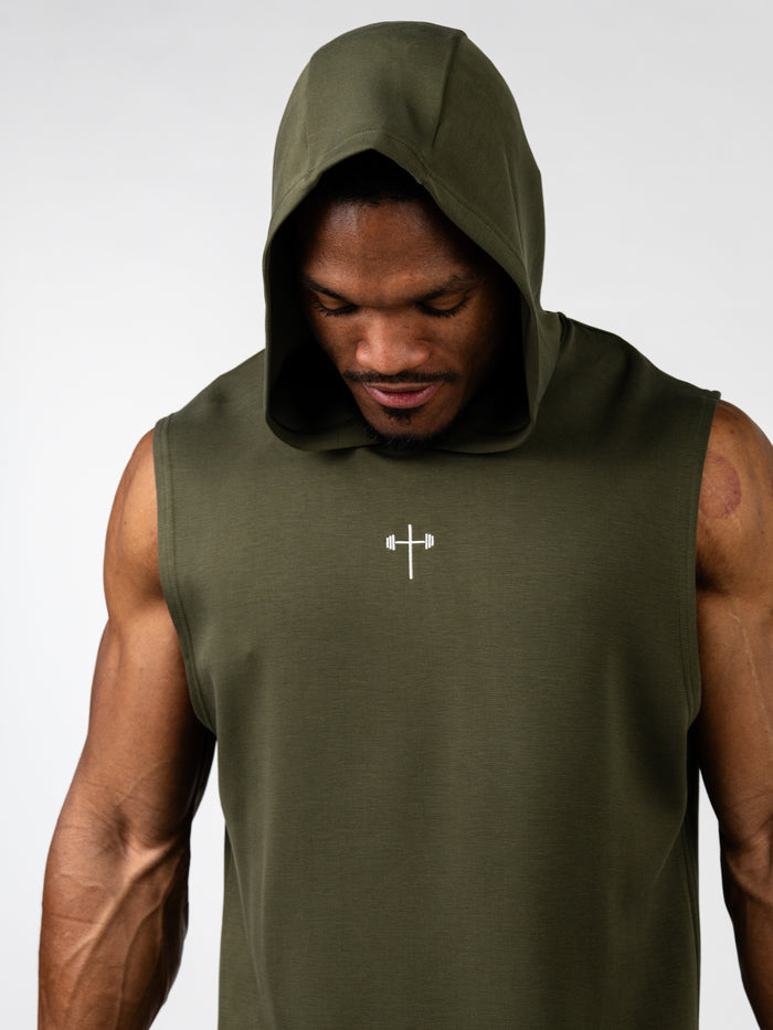Athletic man wearing an olive green Essential Sleeveless Hoodie with a hood up, featuring a small white cross and barbell symbol on the chest, representing Christian fitness apparel.