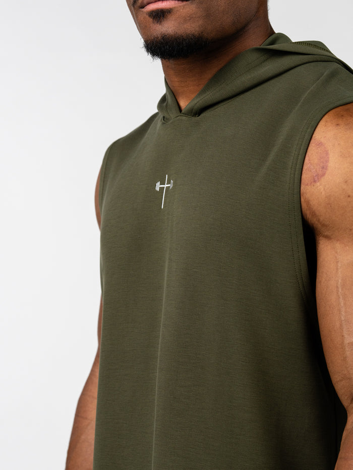 Close-up of a man wearing an olive green Essential Sleeveless Hoodie featuring a small white cross and barbell design on the chest, combining Christian fitness apparel with workout comfort.