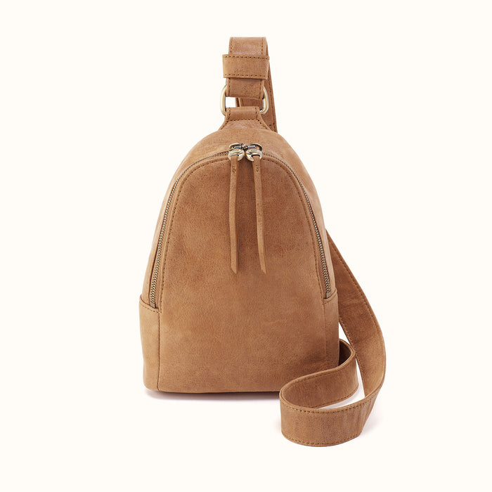 A tan suede shoulder bag with a top zipper, drawstring detail, and a matching adjustable shoulder strap, shown against a plain white background.