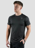 Man wearing a black athletic shirt with a brand logo on a light gray background