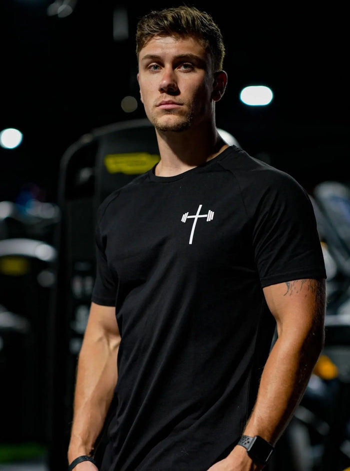 Man wearing a black t-shirt with a white logo, front gym view
