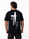 Man wearing a black Phil 4:13 Premium Oversized Tee featuring a large white cross design with the scripture reference Philippians 4:13 and the quote "I can do all things through Christ which strengtheneth me" on the back.