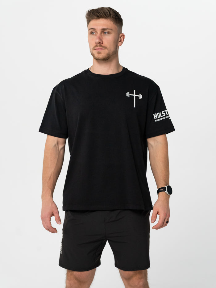 Man wearing a black t-shirt with a logo and text on a white background