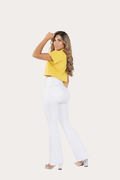 Woman wearing a yellow top and white pants on a white background