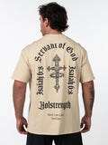 Man wearing a beige Servant of God Premium Oversized Tee with a detailed black cross and crown of thorns graphic on the back, accompanied by text referencing Isaiah 6:8 and Holstrength, showcasing Christian fitness apparel.