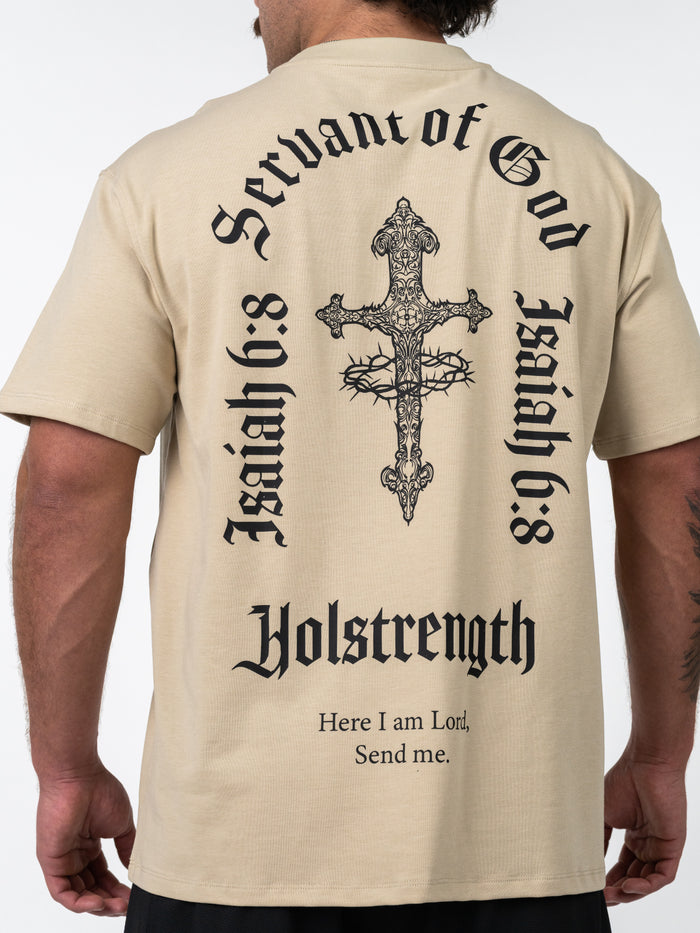 Man wearing a beige Servant of God Premium Oversized Tee with a detailed cross and crown of thorns design on the back, surrounded by Isaiah 6:8 text and Holstrength branding.