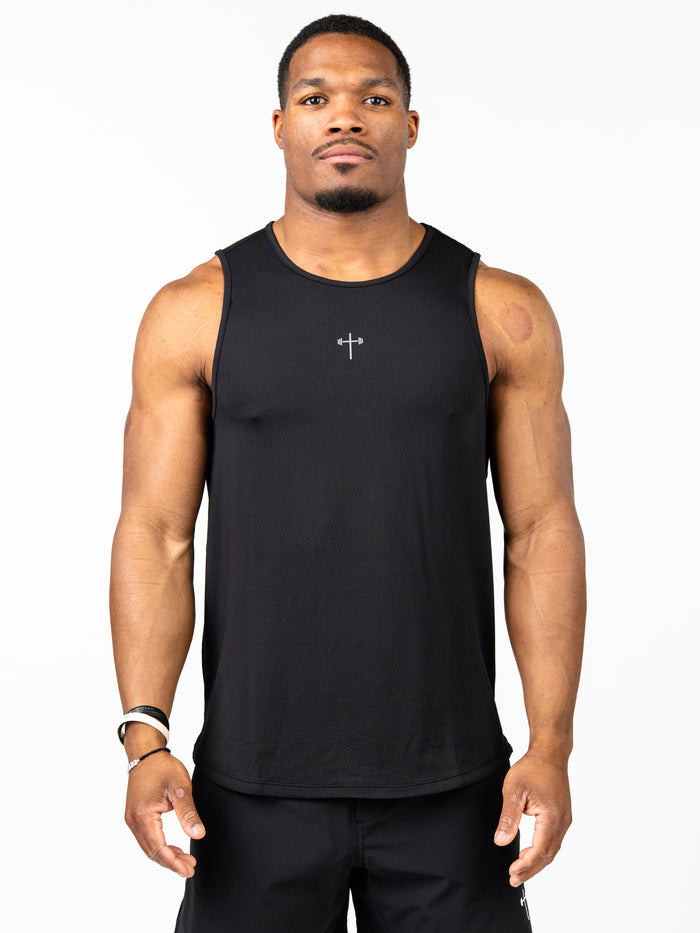 Athletic man wearing a black Signature Tank with a subtle Christian cross and barbell graphic on the chest, designed for performance and faith-based fitness.