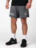 Man wearing gray Signature-Tech Liner Shorts featuring a Christian barbell cross logo and Proverbs 27:17 scripture on the left leg, paired with white socks and black Nike sneakers for training.