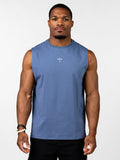 A muscular man wearing a blue Vital Cross Sleeveless Tank featuring a small white Christian cross with a barbell design on the chest, styled as Christian gym clothing for high-intensity workouts.