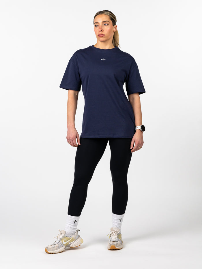 Woman wearing a navy blue athletic outfit on a white background