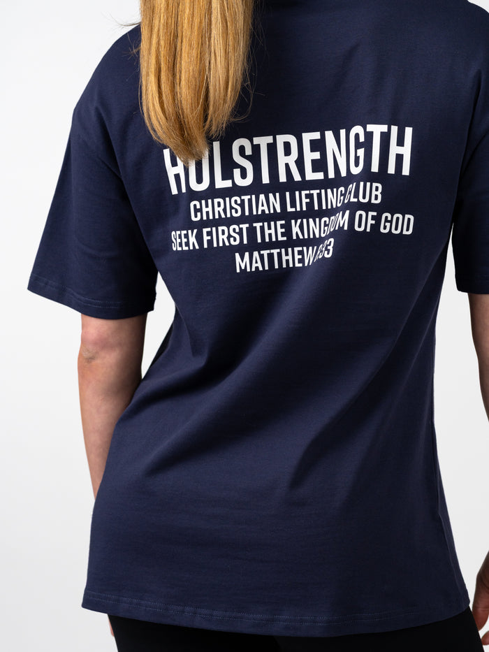 Navy blue t-shirt with white text on the back, worn by a person.
